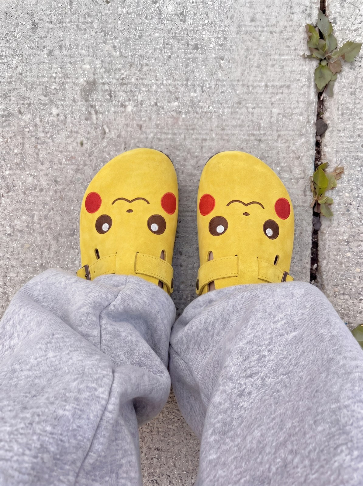 Pikachu clogs worn with grey sweatpants, outdoor